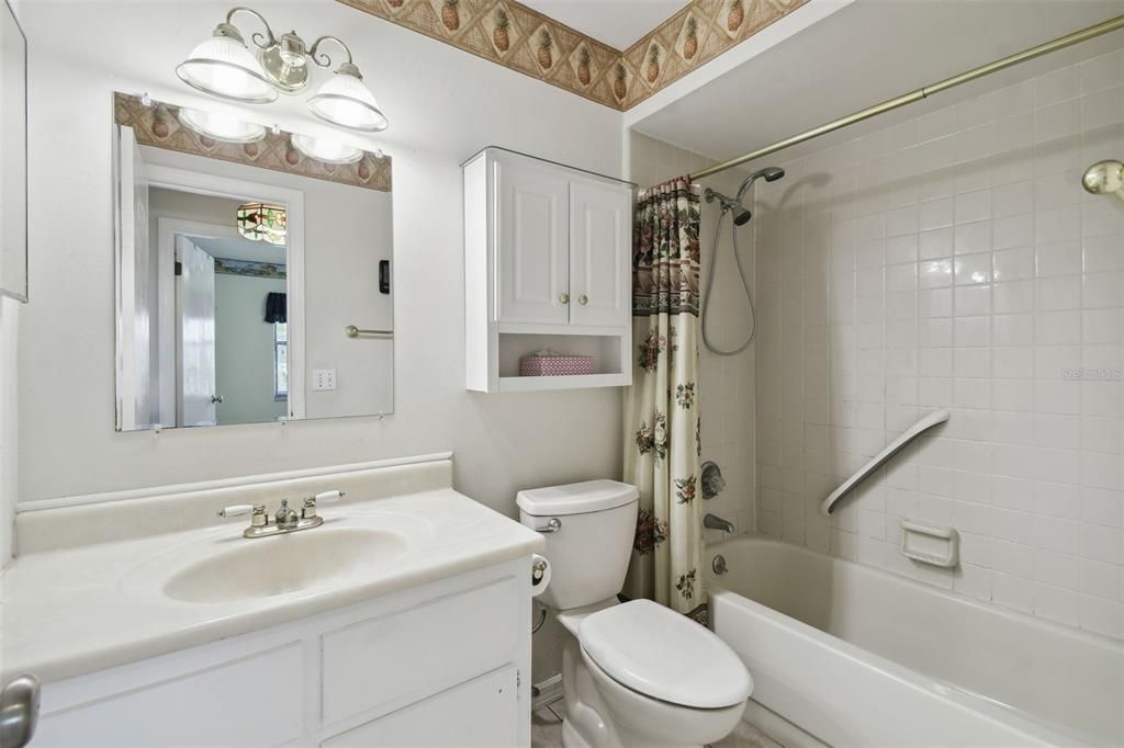 Guest/2nd full bathroom with tiled shower/tub and cultured marble topped vanity