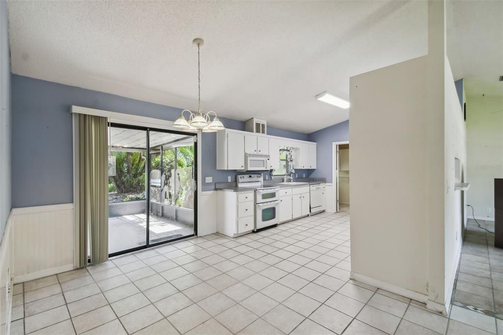 Large dining area adjacent to the kitchen with sliders to the screened lanai and backyard pool area