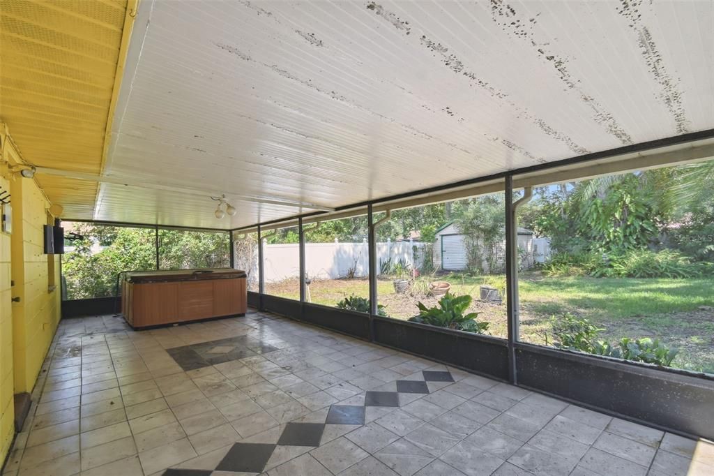 Huge screened and tiled lanai off the dining room/kitchen and primary bedroom - freestanding hot tub works and conveys as-is (leaks a little)