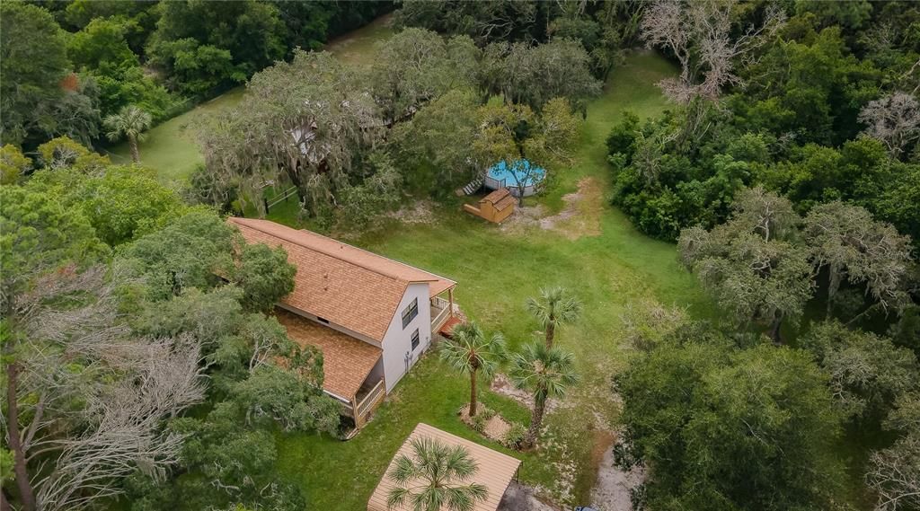 Aerial view of pool and home with carport