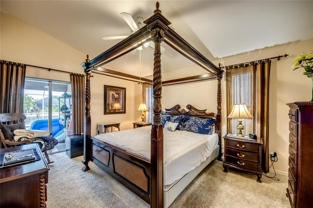 Primary bedroom with sliders to the lanai/pool. Very upscale furniture.