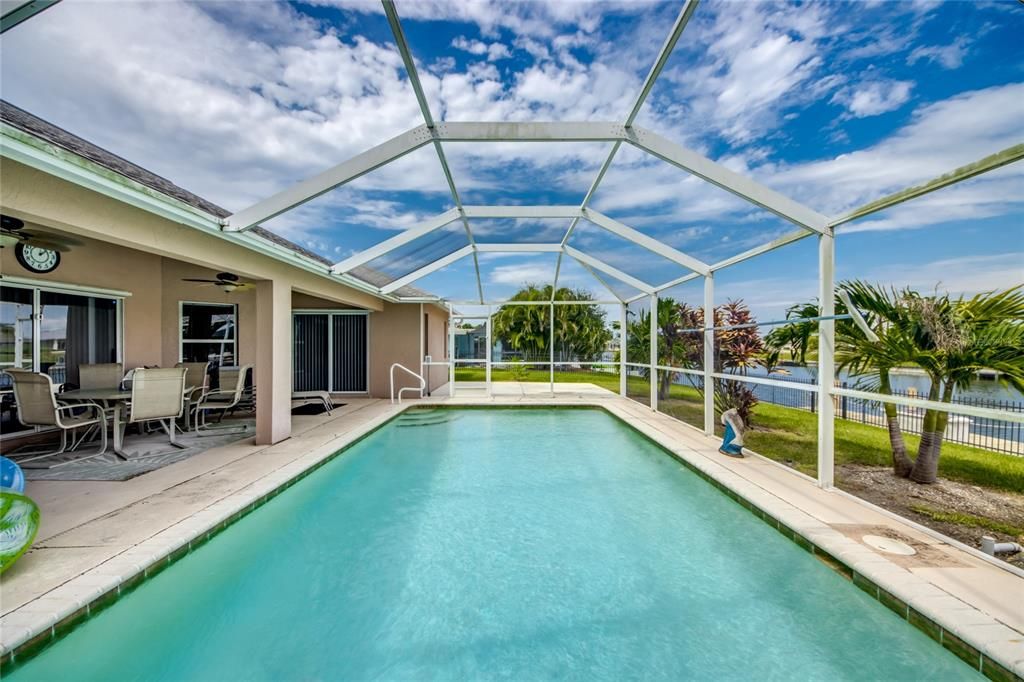 Screened in pool with canal view.