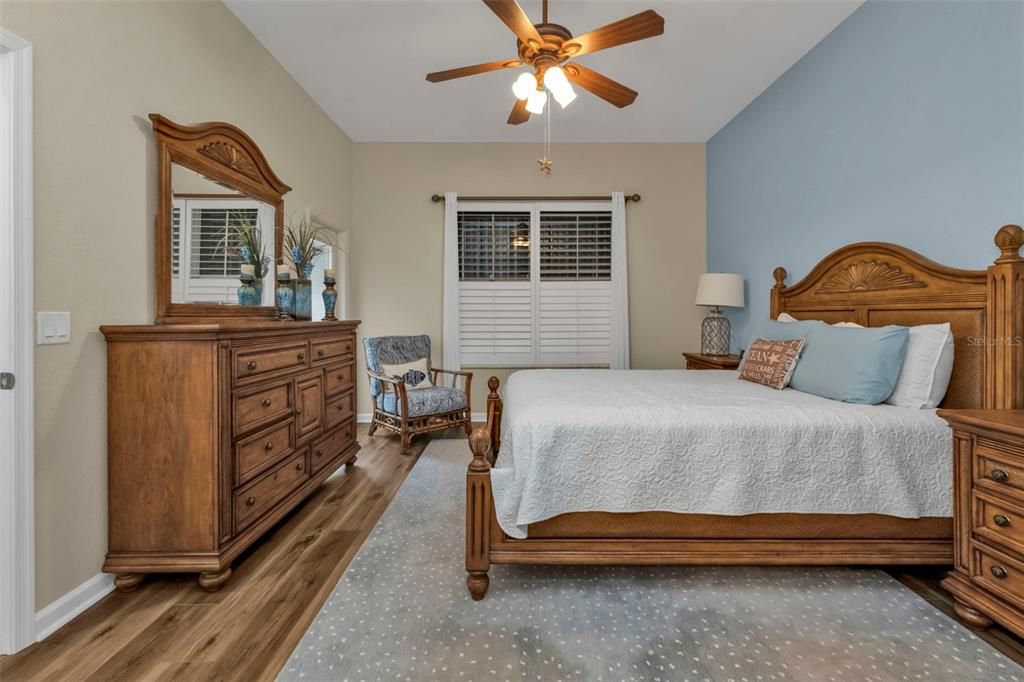 PRIMARY BED WITH PLANTATION SHUTTERS VIEW OUT TO WATER VIEW