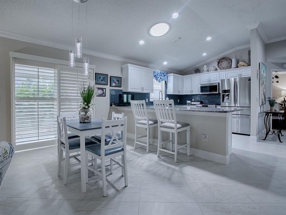 THE DINING ROOM OPEN WITH SLIDING GLASS DOORS OUT TO THE SIDE COURTYARD.  PLANTATION SHUTTERS THROUGHOUT THE HOME.