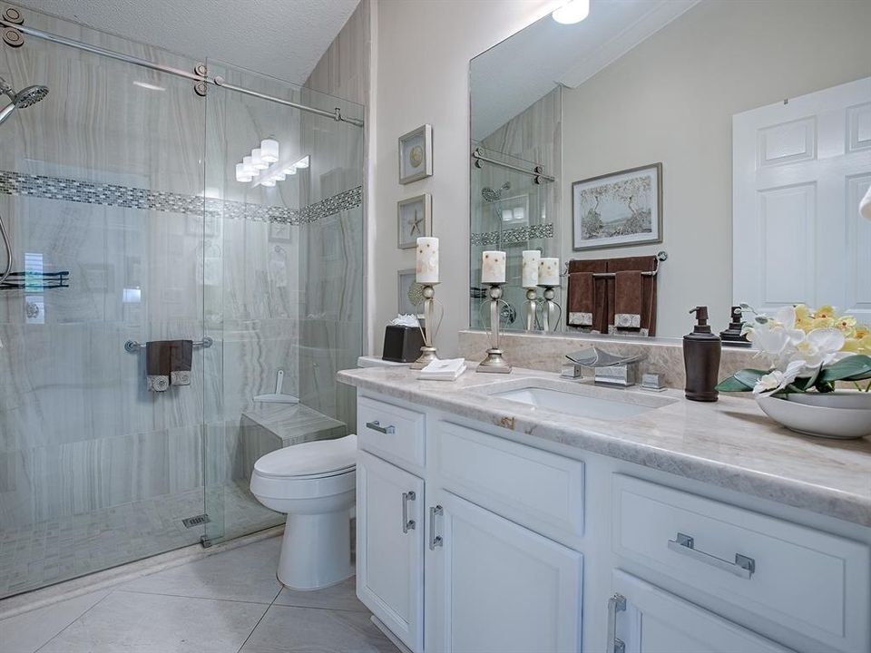 BEAUTIFUL UPGRADED GUEST BATH WITH GRANITE COUNTERTOPS, NEW TILED SHOWER WITH FRAMELESS GLASS DOORS.  NEW TOILET TOO.