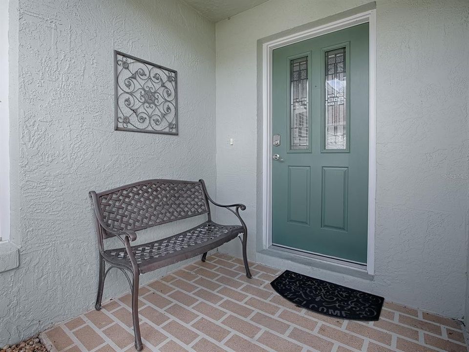 STAMPED CONCRETE ENTRANCE WITH LEADED GLASS FRONT DOOR.