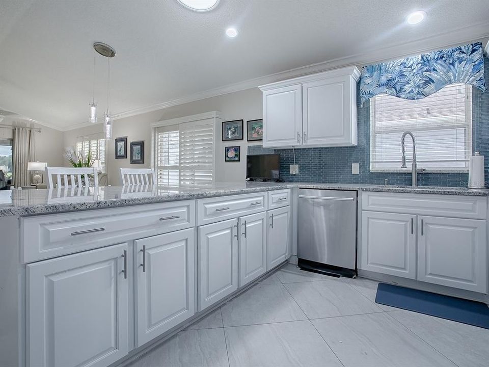 SPACIOUS KITCHEN WITH WHITE CABINETRY AND NICKEL HARDWARE.