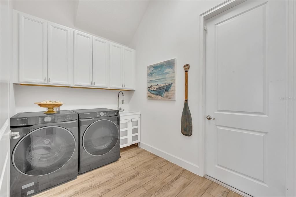 Laundry room with sink and cabinets for extra storage.