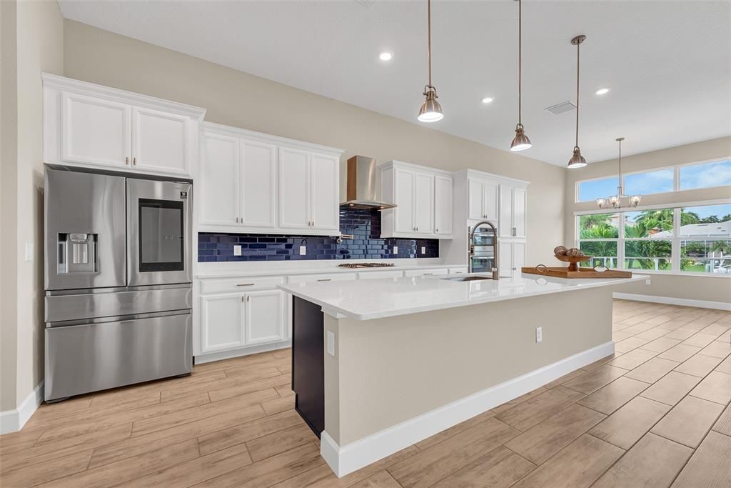 Beautiful island kitchen with stainless appliances and quartz counters. The eat-in area overlooks for pool and water.