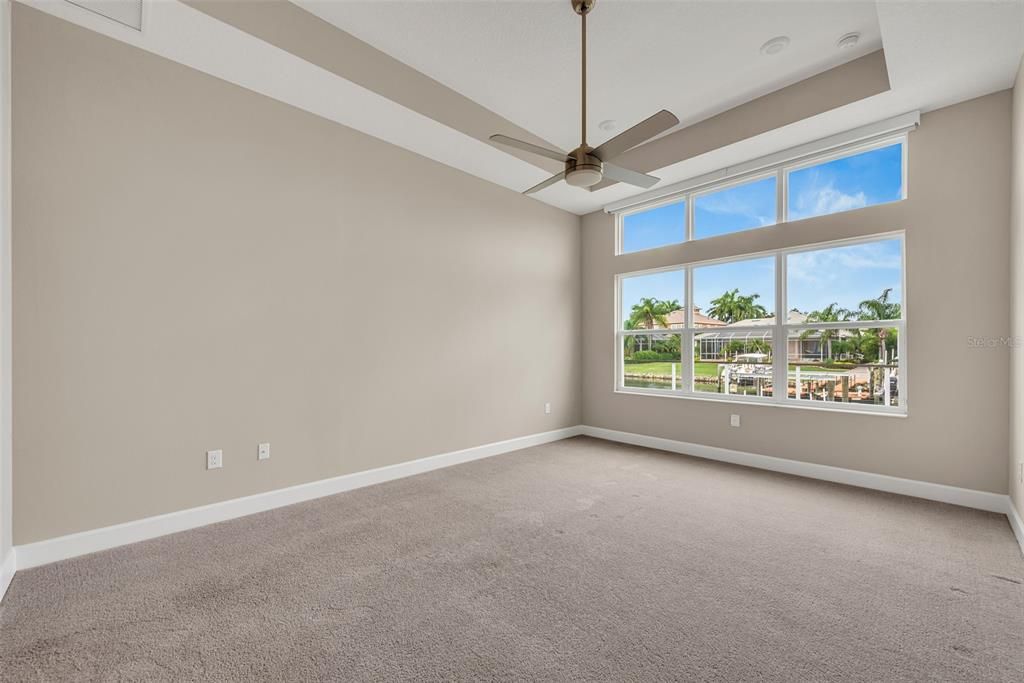 Primary bedroom is on the first floor and features a tray ceiling  and overlooks the water.