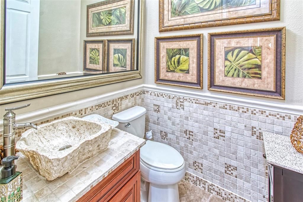 Power Room is CONVENIENT, right off the great room with UNIQUE PETRIFIED WOOD SINK, CUSTOM TILE, framed mirror too!