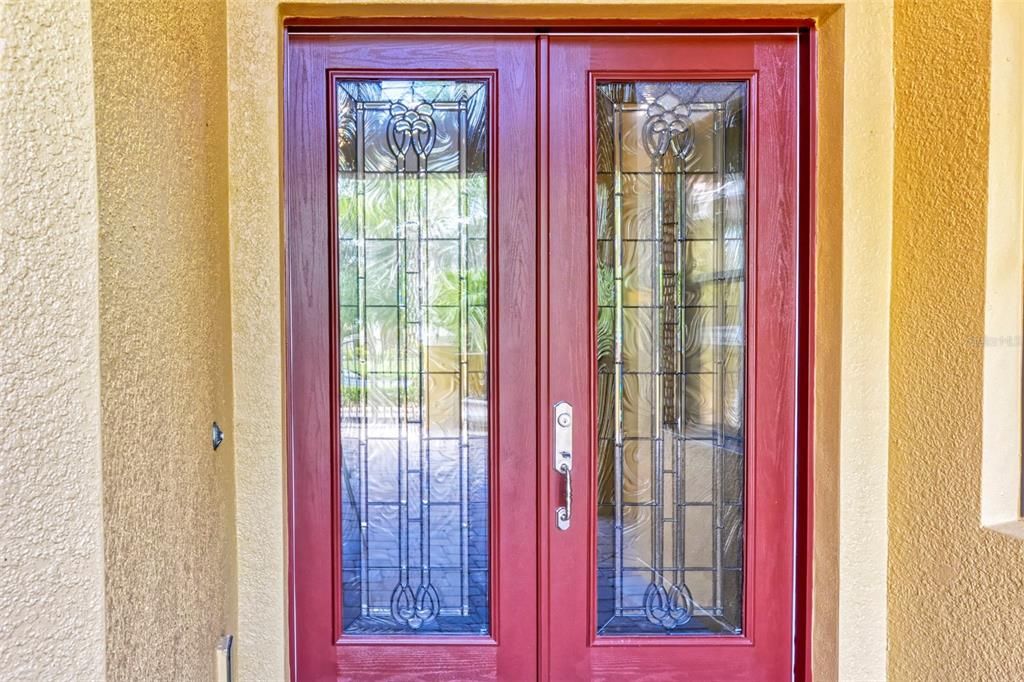 Enter through these CUSTOM LEADED GLASS double doors into a large foyer