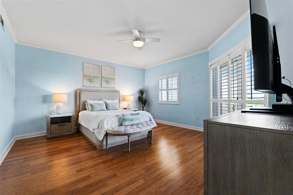 Primary Bedroom with plantation shutters and a slider out to the balcony