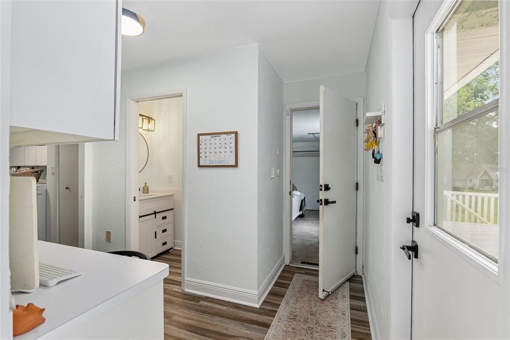 Half bath with pool door, garage door, and home office command center.