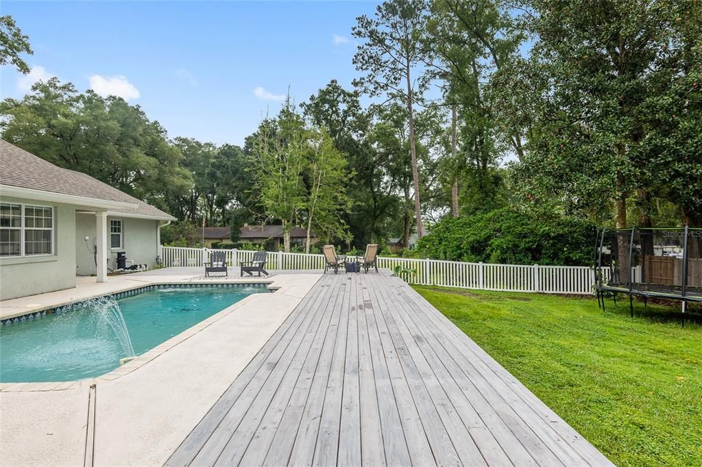 Large backyard beyond poolAnd deck, all fully enclosed.