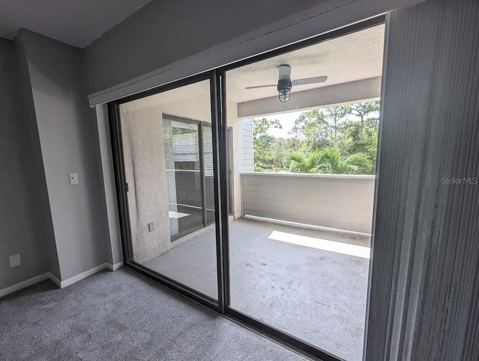 Covered patio off primary bedroom with access to kitchen and laundry area