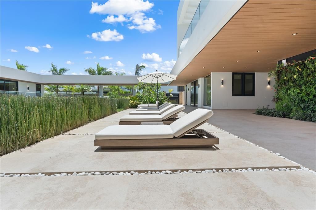 Composite teak on the exterior ceiling and living wall create the ultimate resort vibe with integrated LED Lights surrounding the courtyard pool.