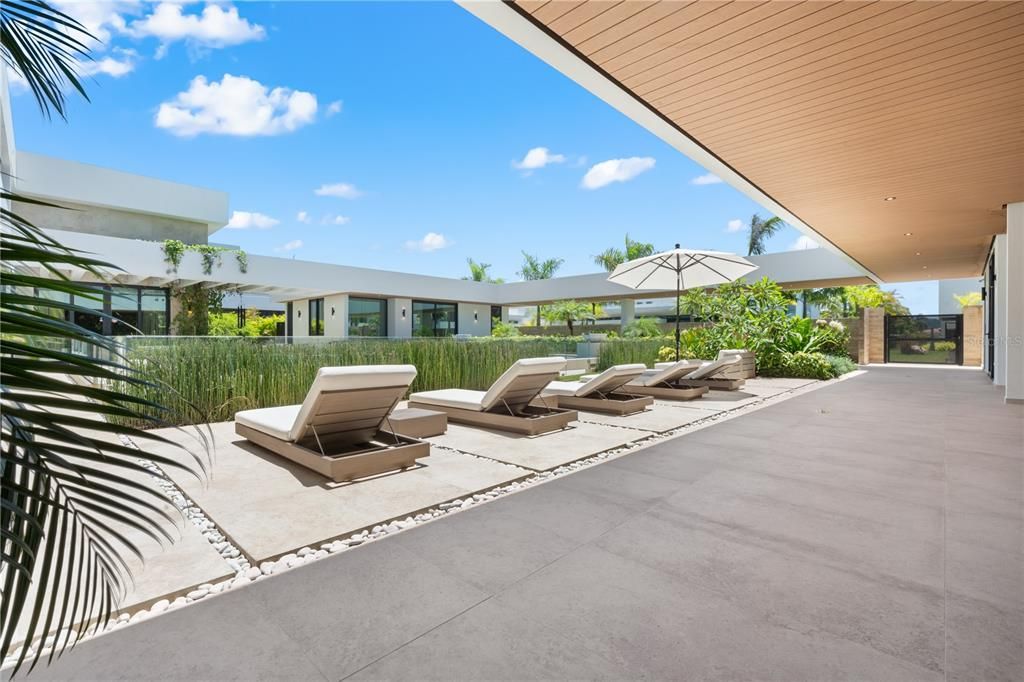 Composite teak on the exterior ceiling and living wall create the ultimate resort vibe with integrated LED Lights surrounding the courtyard pool.