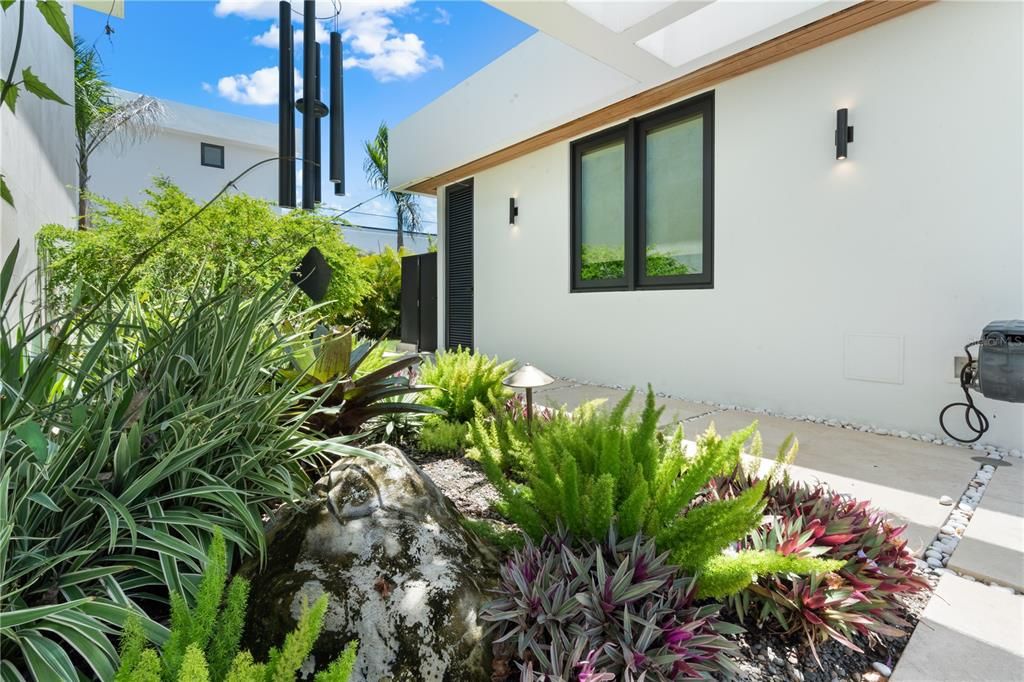 Tiled pathway to exterior shower and guest house #1 on the right side.