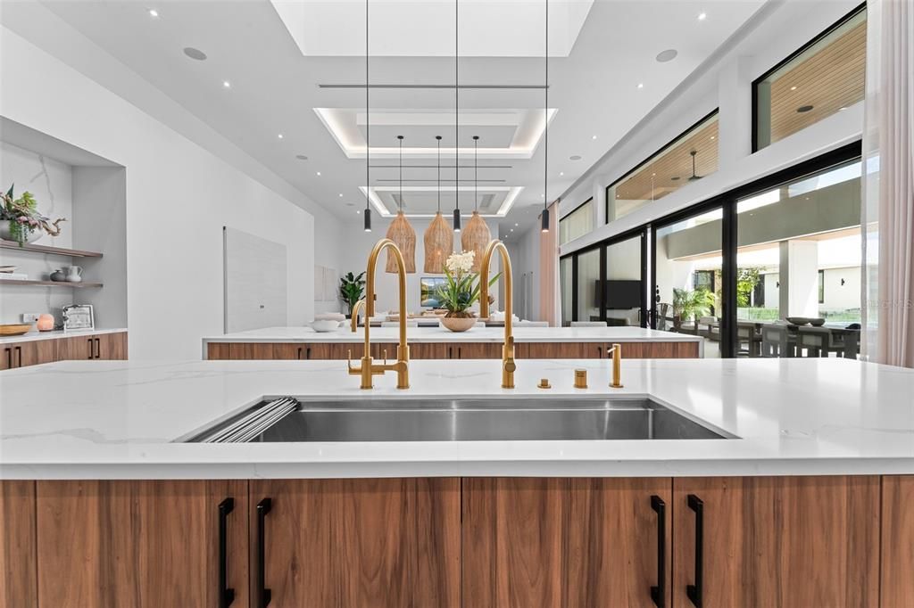 Black and brass accents throughout the home create a contemporary modern feel. Seen above is one of the impressive dual island kitchens with four foot sink.