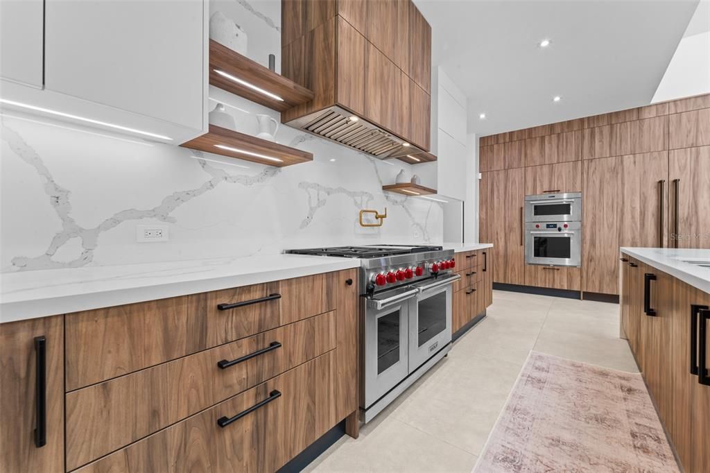 This kitchen has paneled appliances with subzero refrigerator and freezer, wolf gas Range, dual dishwashers.