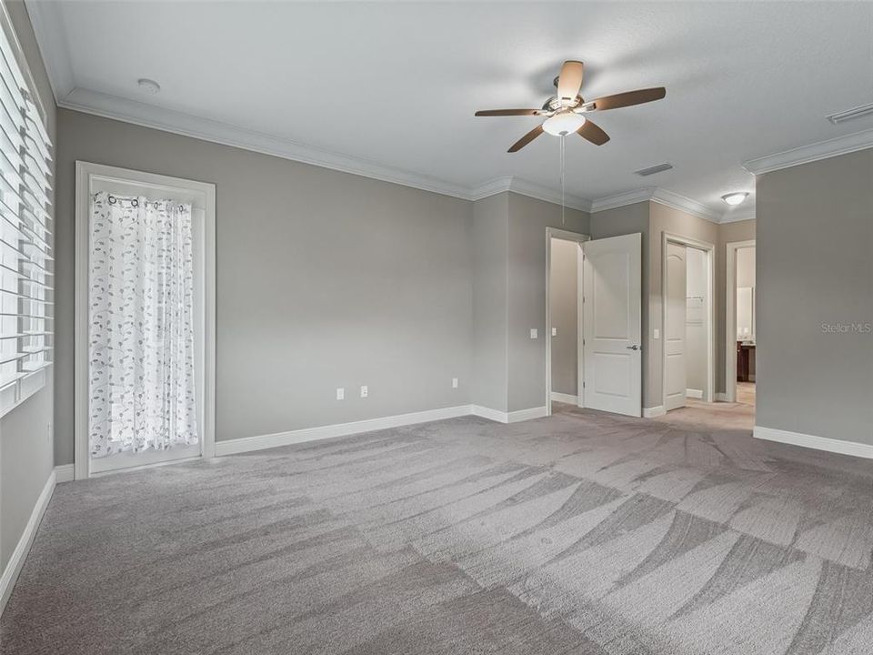 Primary bedroom with door to lanai and pool