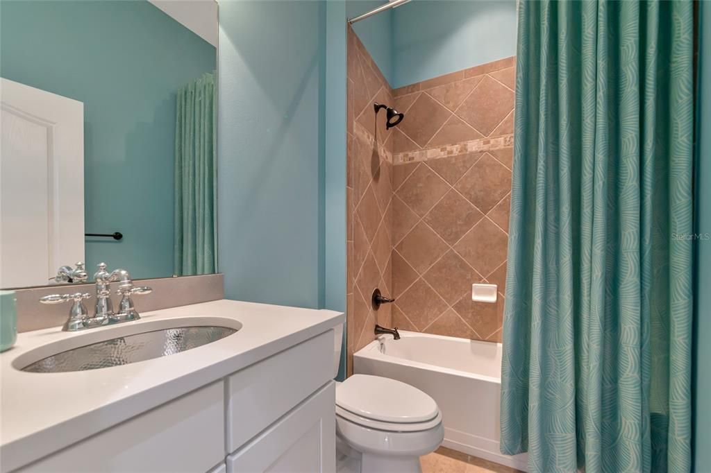 Bath 2 - Quartz Countertop w/ silver Sink. White Cabinetry. Beautifully Tiled Tub/Shower