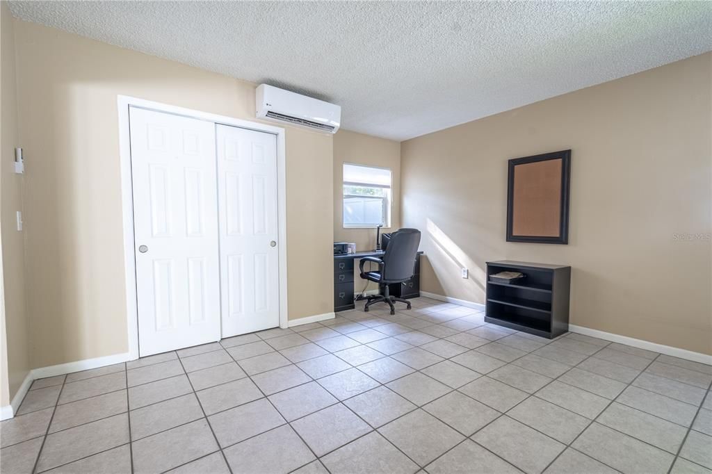 The family room features a built in closet, a mini split for added comfort, a neutral color palette and ceramic tile floor.