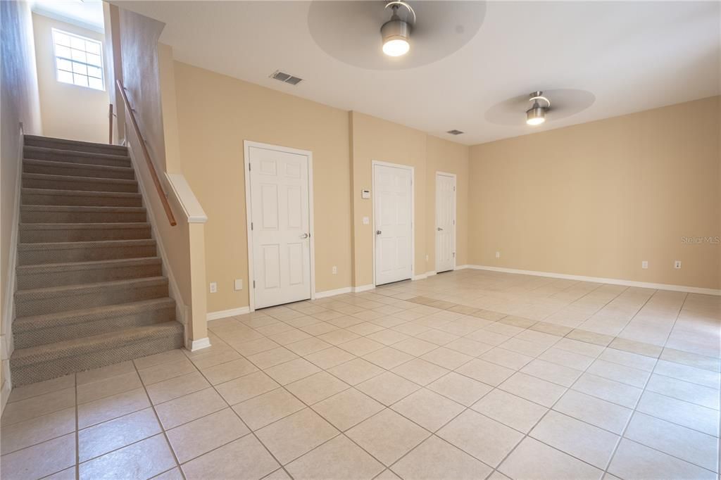 The first floor "Bonus or Flex Room" features ceramic tile flooring, a built in closet, two ceiling fans and access to the two-car garage.