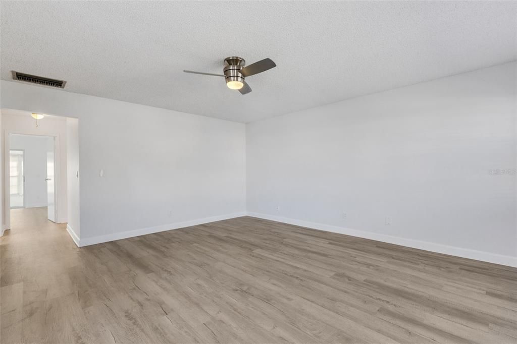 Living Room with new paint, new ceiling fan, new floors.