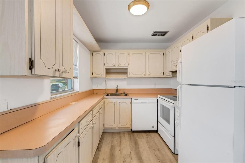 Kitchen with new light fixture and white appliances.