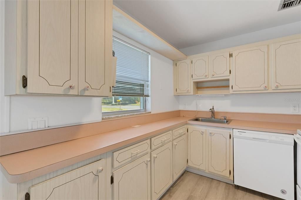 Kitchen with new paint, sunny window and white appliances.