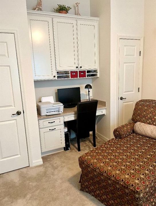 Built in desk in guest bedroom with dual closets