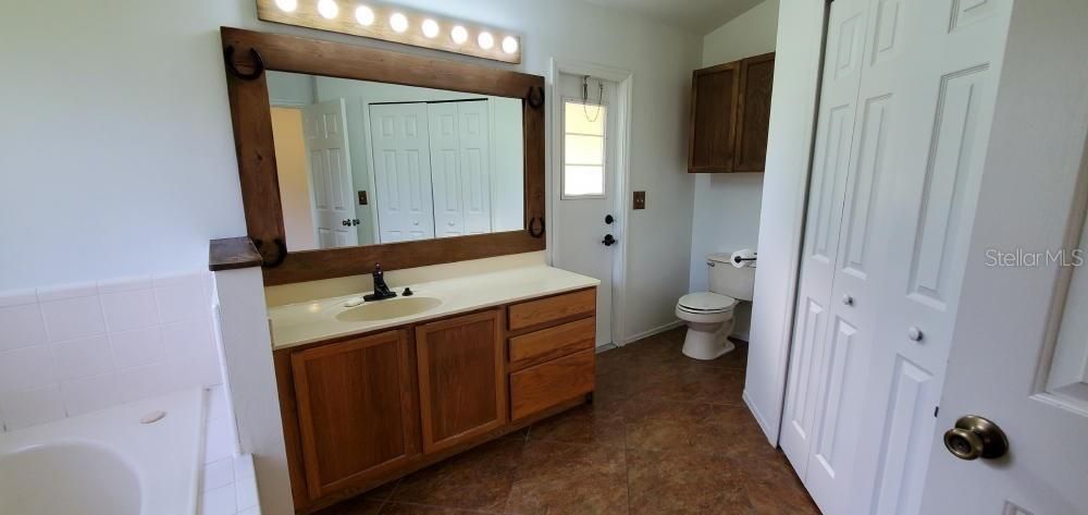 PRIMARY BATHROOM W/ WHIRLPOOL TUB & SEPARATE SHOWER. DOOR TO BACK PORCH.