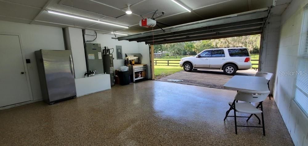 GARAGE W/ GARAGE DOOR OPENER & FREEZER AND WORK BENCH THAT CONVEY.