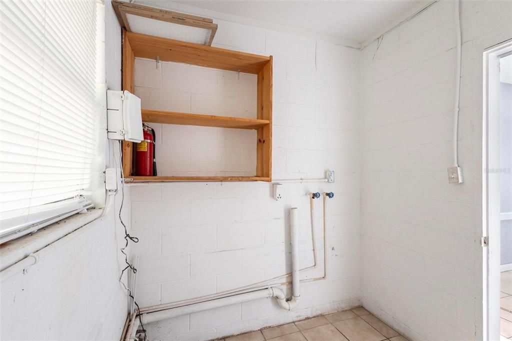 Utility room for washer, dryer and hot water heater. Has plumbing available for second bathroom