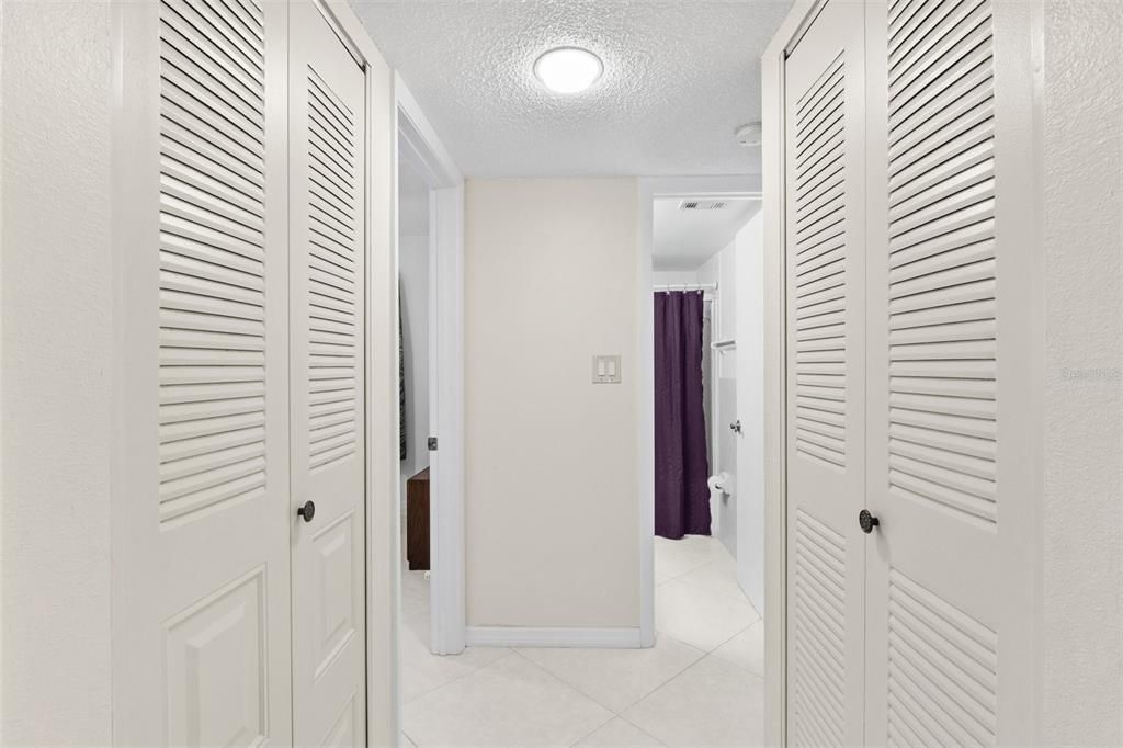 hallway leading to second bathroom and two bedrooms