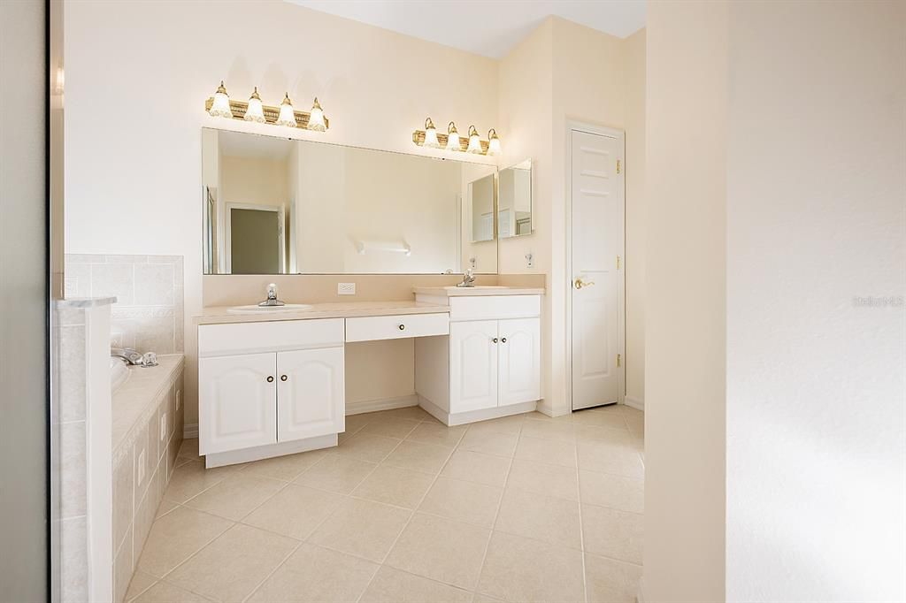 Main bathroom with dual sinks, separate shower stall and garden bath