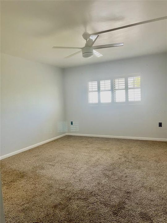 Light bright spacious master bedroom with charming shutters