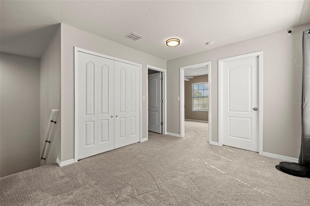 Bonus Room!  Double Closet Doors are where the Washer and Dryer are housed!  Bedroom 3 is straight ahead & Guest Full Bath has the Door open!