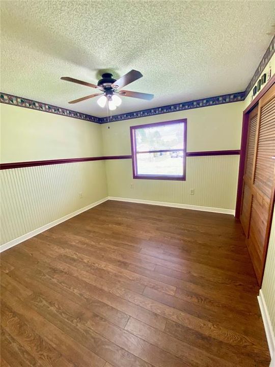 Bedroom 3, located in the Front of the Home with Built-In Closet, Lighted Ceiling Fan, Chair Rail, Beautiful Flooring.......  View is the Front Yard