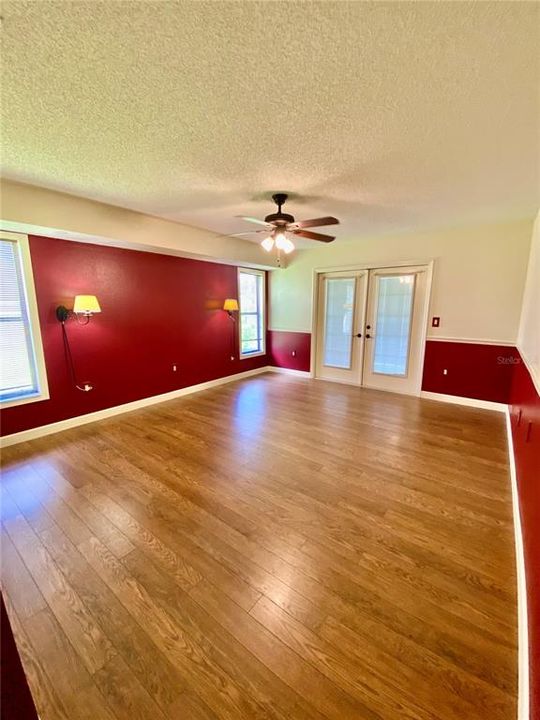 Spacious Primary Bedroom with French Doors to the Lanai,  Lighted Ceiling Fan, Engineered Hardwood Floors