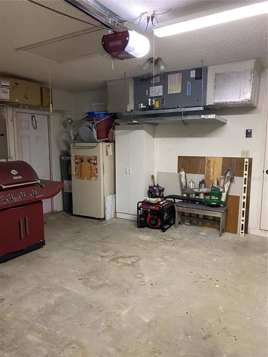 Front of Garage Showing the Side Door, Air Handler, Stair Pull Down for Attic Storage, Plus Garage Door Opener....