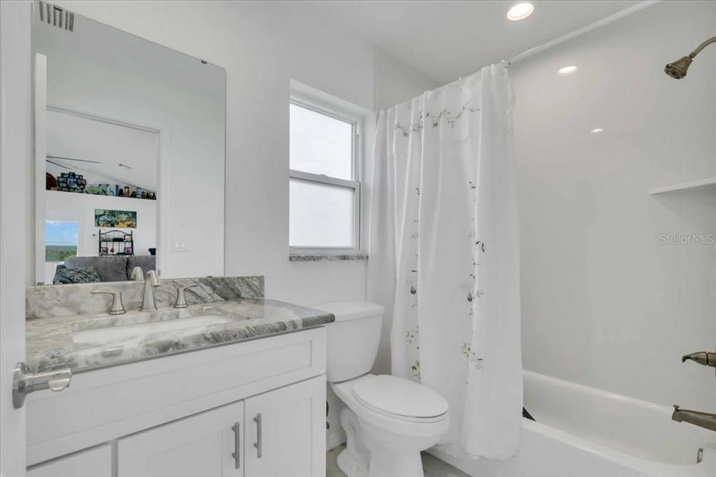 Tub/Shower Guest Bathroom.  White Shake Cabinet & Marble Looking Granite Counter