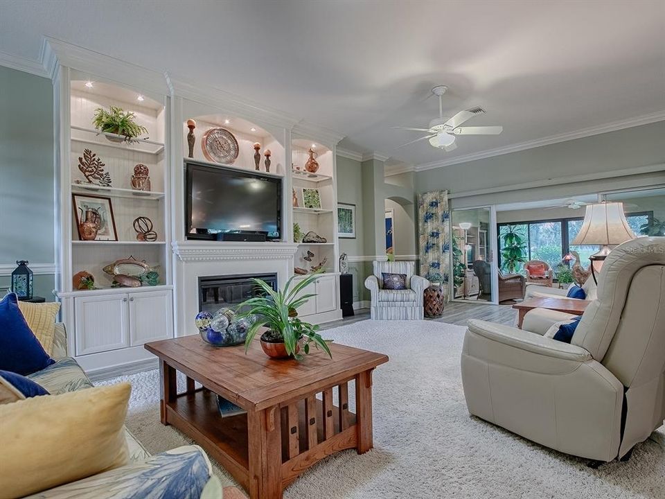 CUSTOM BUILT-IN LIGHTED BOOKCASE AND FIREPLACE.