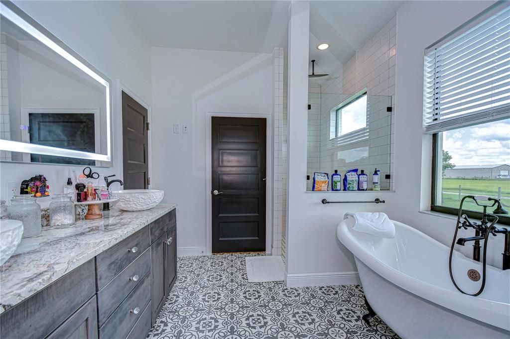 En suite bathroom with claw foot tub, walk in shower and dual vessel sinks!