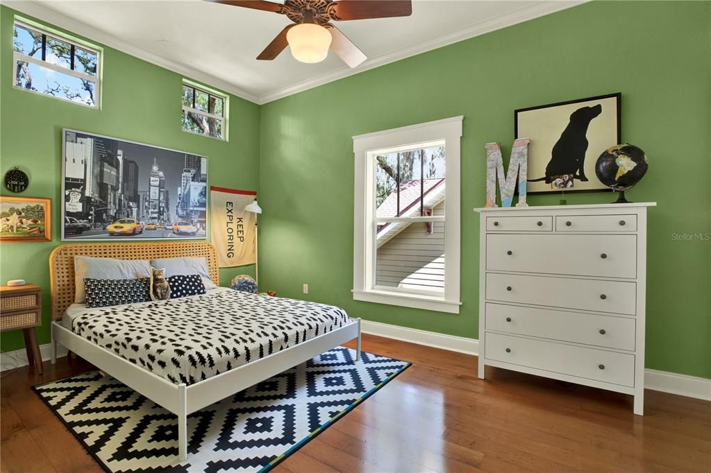 A second full bath upstairs features a bathtub/ shower combo and the same warm wood cabinetry and stone countertops