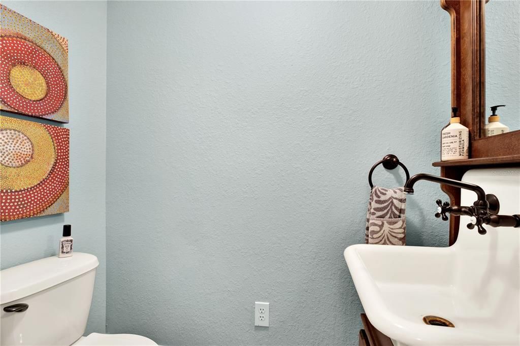 The downstairs hall bath is a testament to well done furniture repurposing with its cabinet clad farmhouse sink