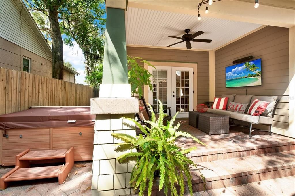 A hot tun and inviting covered porch sit right outside the downstairs primary bedroom