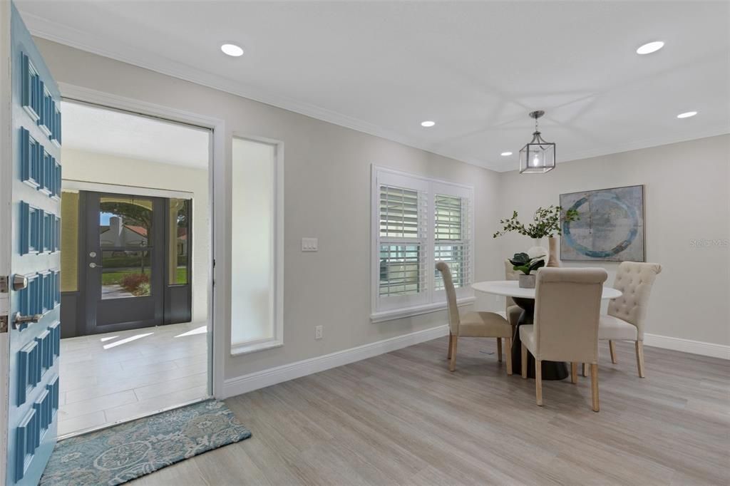 A beautiful entryway with new driftwood tone luxury vinyl, crown molding & baseboards throughout~